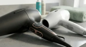 Close-up of the ergonomic handles, showing the professional model's precision toggles and cold shot button versus the simple sliding switch on a regular hairdryer.