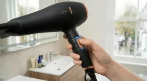 A finger pressing the cool shot button to set a hairstyle and add a healthy-looking sheen.