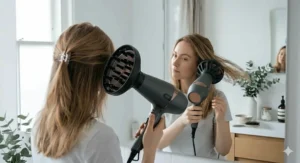 A ceramic hair dryer with a large diffuser attachment being used to enhance natural waves in fine hair without frizz.