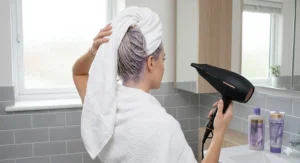 Freshly washed blonde hair being dried after using purple shampoo to maintain cool, vibrant tones.