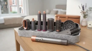 A high-detail flat lay of various grey and copper multi-styler attachments, including curling barrels and smoothing brushes, arranged on a felt tray.