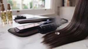 Sleek, frizz-free, shiny straight hair flowing over a woman's shoulder after styling.