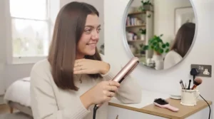 Close-up of ceramic plates gliding smoothly through a sleek section of dark hair