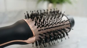 Close-up of the oval-shaped ceramic barrel of a 2 in 1 hair dryer brush showing the mixed bristles.