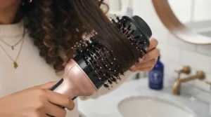 Close-up of mixed tufted bristles on a ceramic styling brush designed to smooth frizz without pulling curls.