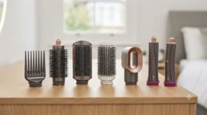 A collection of interchangeable heads for a hair styler, including curling barrels, smoothing brushes, and a drying nozzle.