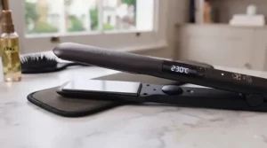 Digital temperature display on a professional hair straightener set to high heat for thick locks.
