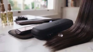 Compact dual-voltage hair straighteners packed neatly inside a stylish wash bag.