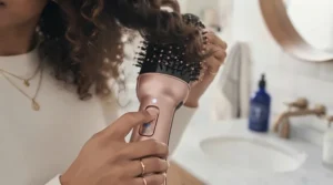 Setting defined curls with the cool shot button on a hair dryer brush to reduce frizz and add shine.