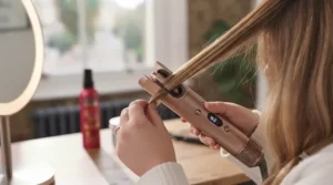 Step-by-step demonstration of an automatic hair curler rotating a strand of hair safely.