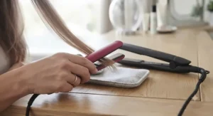 Using a mini travel straightener to touch up a fringe and short hair layers before a night out.