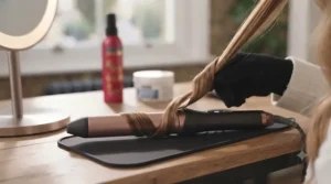 Close-up of a tourmaline ceramic curling wand heating up on a heat-resistant mat.